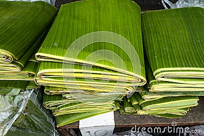 Stack of folded banana leaves displayed at a local market. Stock Photo