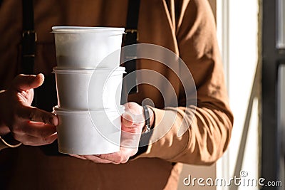 Stack of food delivery boxes. Anonymous hands holding stack of delivery boxes. Craft packaging of delivered food in Stock Photo