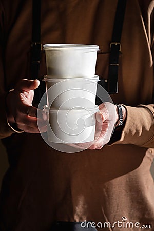 Stack of food delivery boxes. Anonymous hands holding stack of delivery boxes. Craft packaging of delivered food in Stock Photo