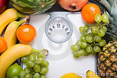 Stack of fruits over white weight scale. Stock Photo