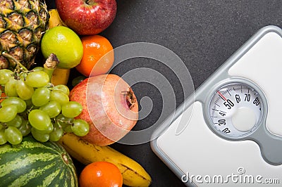 Stack of fruits and white weight scale Stock Photo