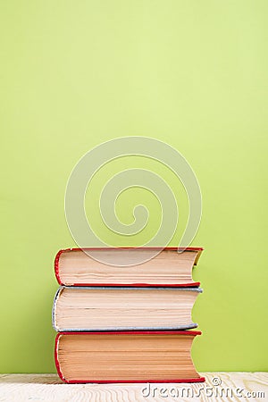 Stack of hardback books, diary on wooden deck table and green background. Back to school. Copy Space. Education Stock Photo