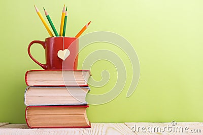 Stack of hardback books, diary on wooden deck table and green background. Back to school. Copy Space. Education Stock Photo