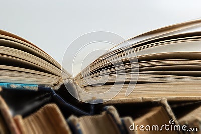 Stack of hardcover old books with an open book on white background. Bookshelf shop, Knowledge publications, literature. Bookish Stock Photo