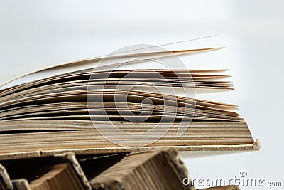 Stack of hardcover old books with an open book on white background. Bookshelf shop, Knowledge publications, literature. Bookish Stock Photo