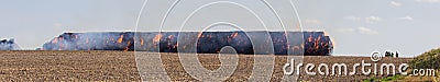 Stack hay in fire on field with firemans Stock Photo