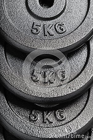 Stack of barbell / dumbbell weight plates inside a weightlifting gym Stock Photo