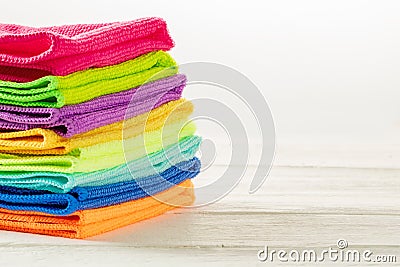 Stack of kitchen microfiber towels in bright colors on a white wooden background Stock Photo