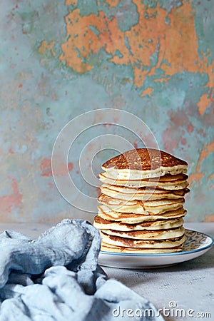 A stack of lush punkcakes for breakfast on a gray background. High pile of delicious pancakes with berries. Stock Photo