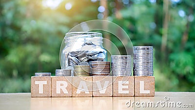 Stack many coins on a wooden block with a travel message. Stock Photo