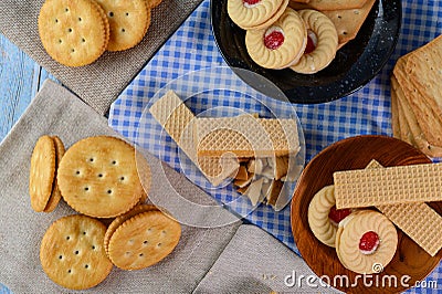 Stack many types of cookies on a plate and put on a wooden table Stock Photo