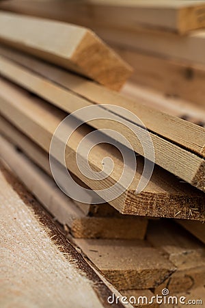 Stack of natural brown uneven rough wooden boards on building site. Industrial timber for carpentry, building Stock Photo