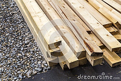 Stack of natural wooden boards on building site. Industrial timber for carpentry, building or repairing, lumber material for Stock Photo