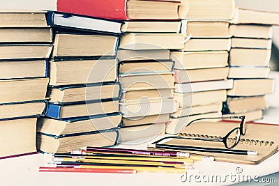 Stack of old books, textbook, notebook, glasses and pencils on white table in office background for education concept Stock Photo