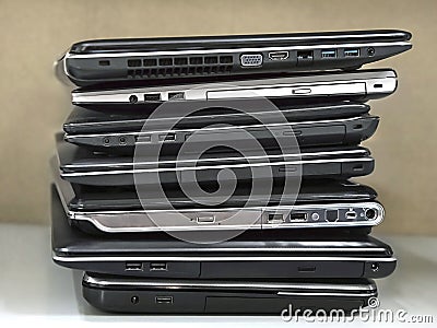 Stack of old laptops awaiting repair Stock Photo