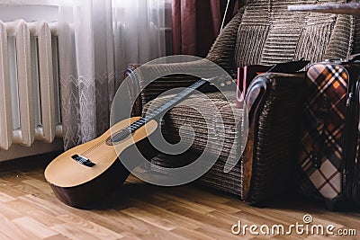 A stack of old vinyl records and acoustic wooden guitar with an amplifier are isolated on a brown background for a music Stock Photo