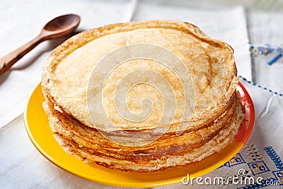 Stack of pancakes. Thin pancakes in a plate and a wooden spoon. Traditional rustic food Stock Photo