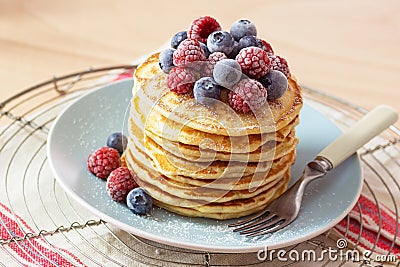 Stack of Pancakes Topped with Frozen Berries and Powdered Sugar Stock Photo