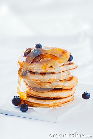 Stack of pancakes topped with honey or syrup Stock Photo