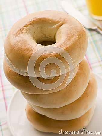 Stack of Plain Bagels with a Glass of Orange Juice Stock Photo