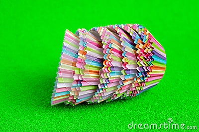 Stack Rainbow colored paper baking cups for muffins and cupcakes on a green background minimal creative concept. Space Stock Photo