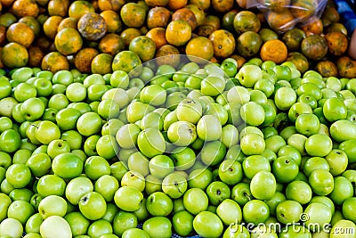 Stack of Raw Green fresh Monkey Apple or Indian Plum or Jujube and Orange in Market Stock Photo