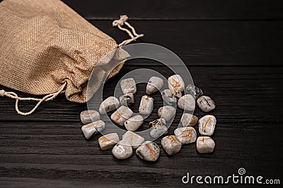 Stack of runes on gray desk. Magic symbols for esoteric divination. Stock Photo
