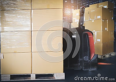 Stack of shipment boxes with electric forklift pallet jack at the warehouse. Cargo export & shipping warehousing. Stock Photo