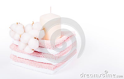 Stack of soft towels. Spa concept. Candle and cotton flowers. Stock Photo