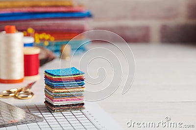 Stack of square pieces of colorful fabrics, accessories for quilting Stock Photo