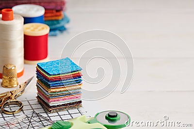 Stack of square pieces of colorful fabrics, accessories for quilting Stock Photo