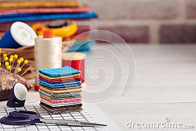 Stack of square pieces of colorful fabrics, accessories for quilting Stock Photo
