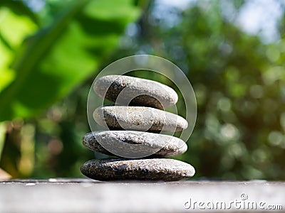 Stack Stone on Blur Plant Growth Tree wit Bokeh Background Texture Circle Pebbles Pyramid on Wood Nature,Concept for Health spa Stock Photo
