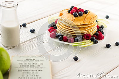 Stack of Sweet Pancakes with Fresh Blueberry, Raspberry, Apple and Maple Syrup on White Light Background Stock Photo