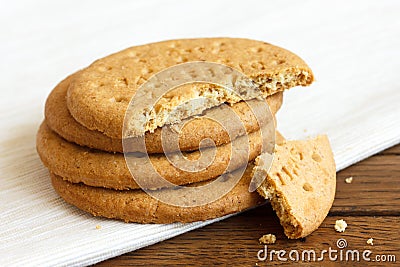 Stack of sweetmeal digestive biscuits on dark wood and napkin. Stock Photo