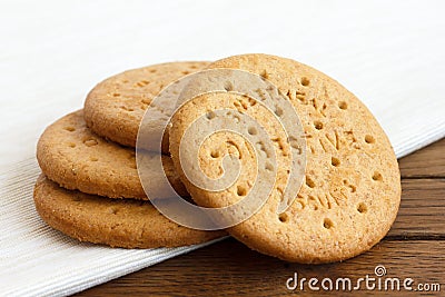 Stack of sweetmeal digestive biscuits on dark wood and napkin. Stock Photo