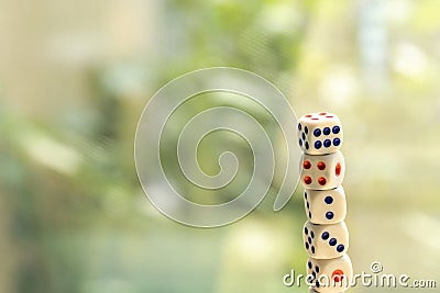 Stack tower of many small game dice isolated on a bright blurred background, group of objects, nobody. Probability and chance Stock Photo