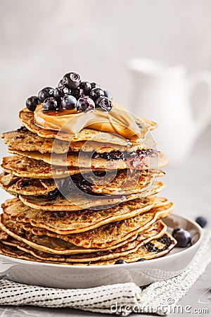 Stack vegan blueberry pancakes with peanut butter and syrup. Stock Photo