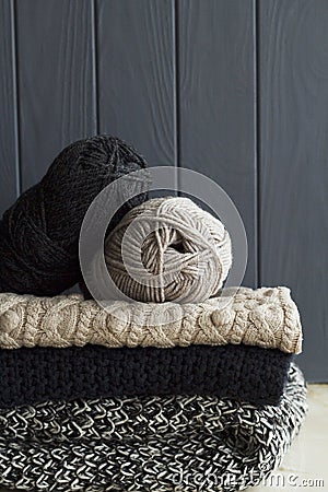 Stack of warm clothes from knitted knitwear over grey wooden background Stock Photo