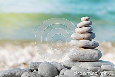 Stack of white pebbles stone against blue sea background for spa, balance, meditation and zen theme. Stock Photo