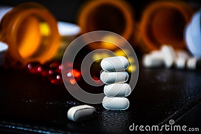 Stack of White Pills with Open Pill Bottle background Stock Photo