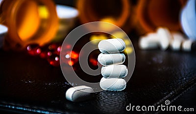 Stack of White Pills with Open Pill Bottle background Stock Photo