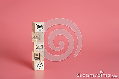 Stack wooden block cube with business icons â€‹on pink background. Stock Photo