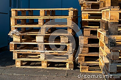 A stack of wooden pallets in an internal warehouse. An outdoor pallet storage area under the roof next to the store. Piles of Euro Stock Photo