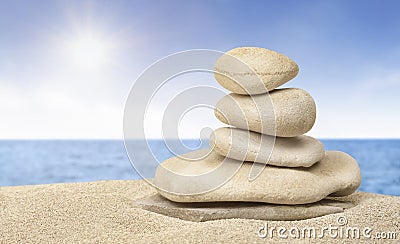 Stack of zen stones on sunny sand beach Stock Photo