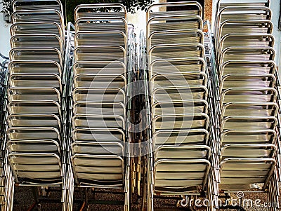 Stacked aluminum chairs next to the terrace of a bar Stock Photo