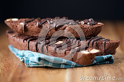 Stacked Chocolate Biscotti on Wood with Black Background Closeup Stock Photo