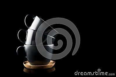 Stacked Coffee Cups, Three Dark Modern Cups stacked on a wooden tray with place for your text Stock Photo