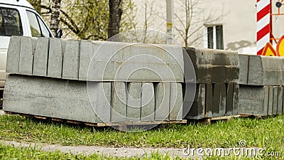 stacked concrete pavement blocks lie on the grass,background Stock Photo