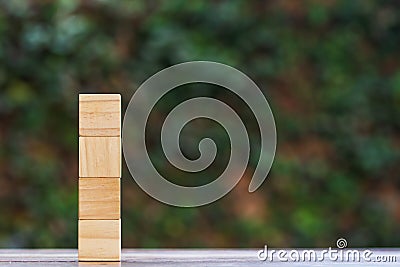 Stacked empty four wooden block on wood table with green nature background and space at right use for input your text Stock Photo